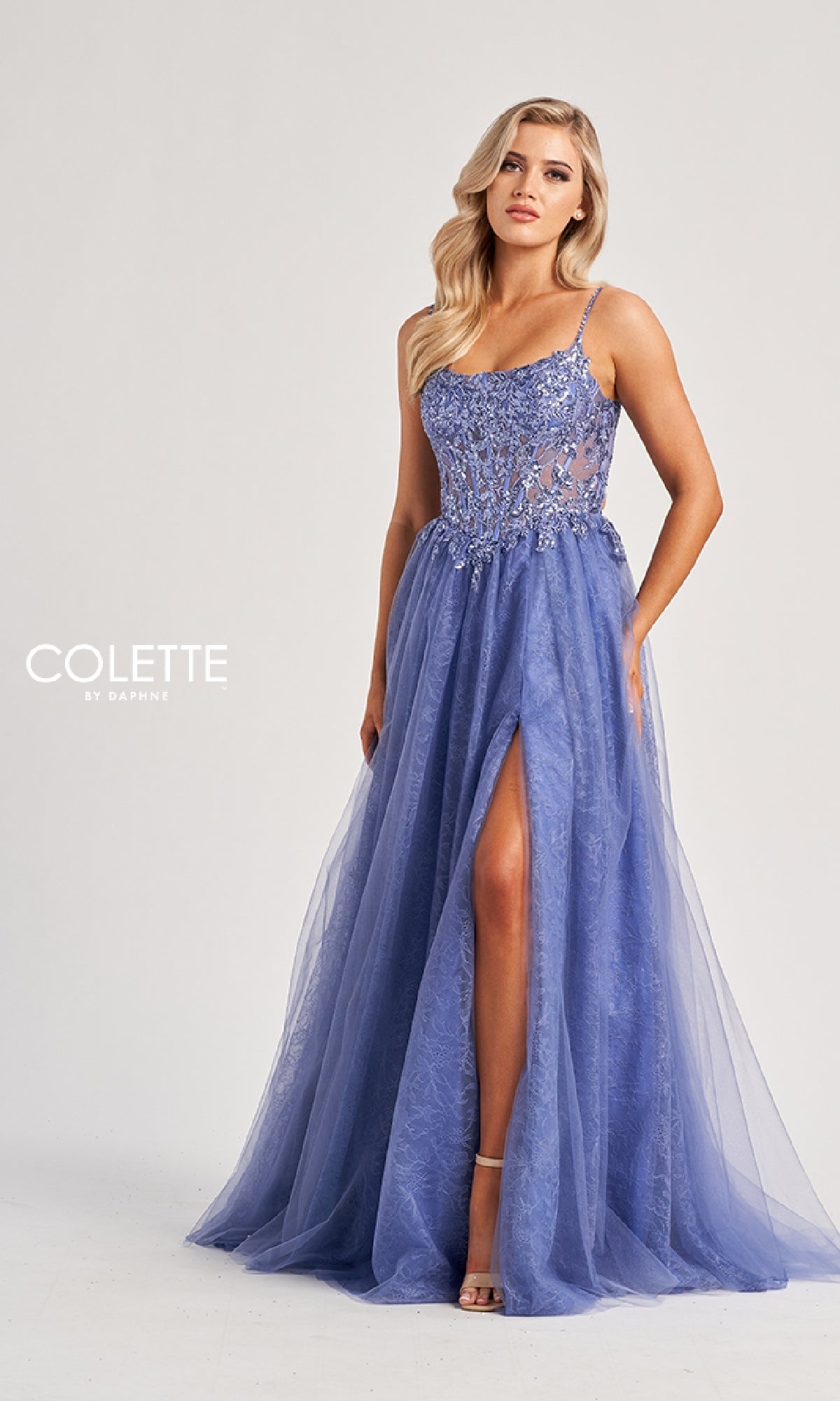 A woman models the Colette CL8240 long prom dress in lavender, featuring a floor-length skirt, embroidered sheer bodice, and thigh-high slit, against a plain light background.